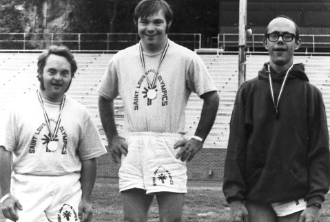 Three young men receive medals