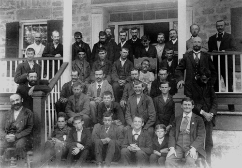 Male residents gather on the front steps of their dormitory
